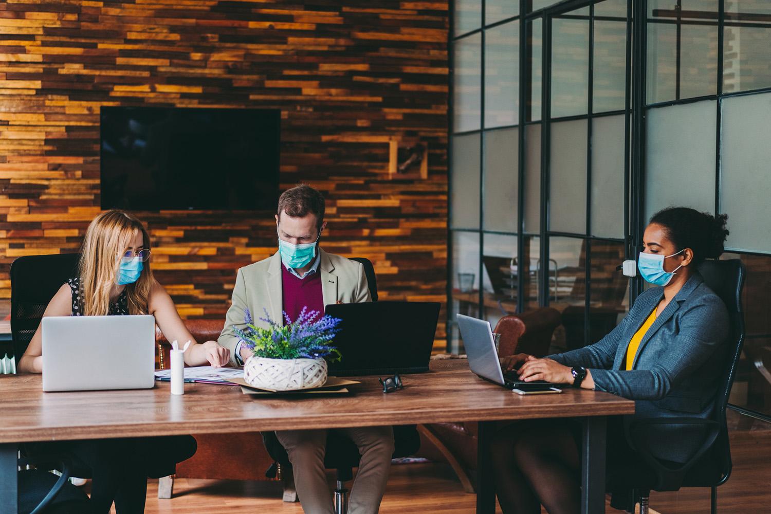Businesspeople wearing masks in the office during COVID-19 pandemic