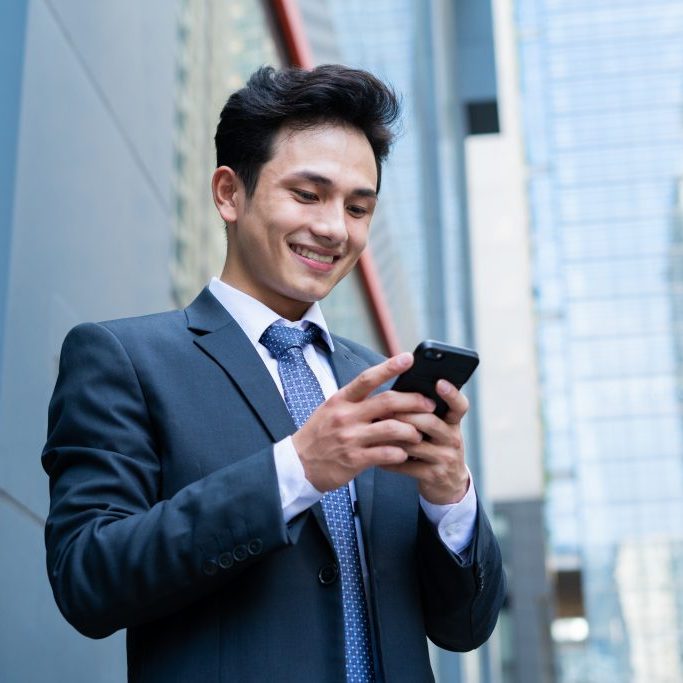 Young,Asian,Businessman,Using,Smartphone,To,Text,Message