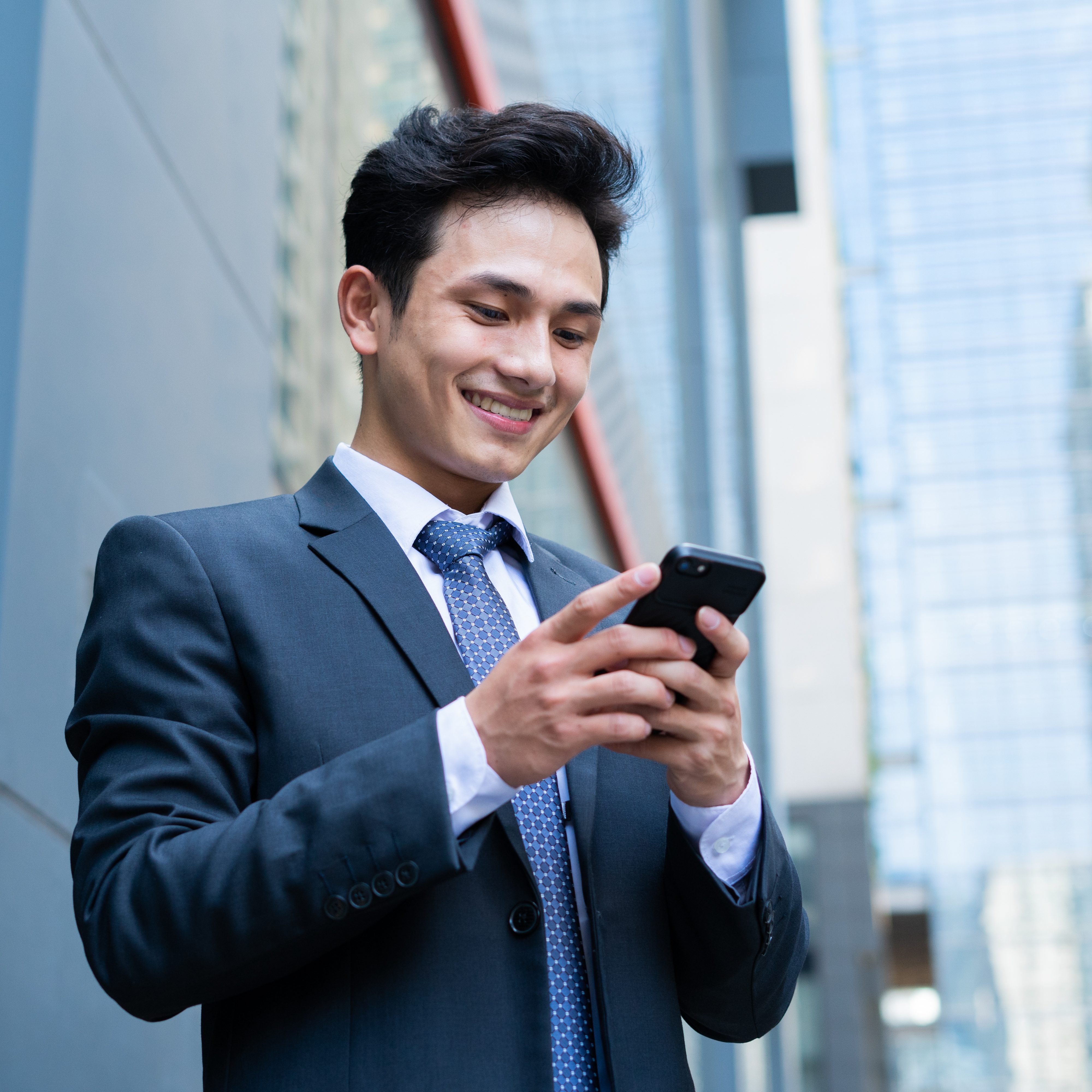 Young,Asian,Businessman,Using,Smartphone,To,Text,Message